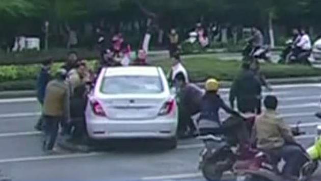 Bystanders lift car off of trapped cyclist