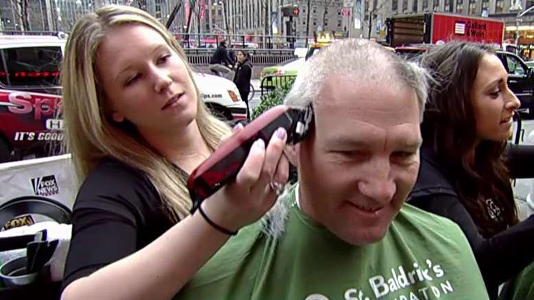 Volunteers shave their heads to help cure childhood cancer