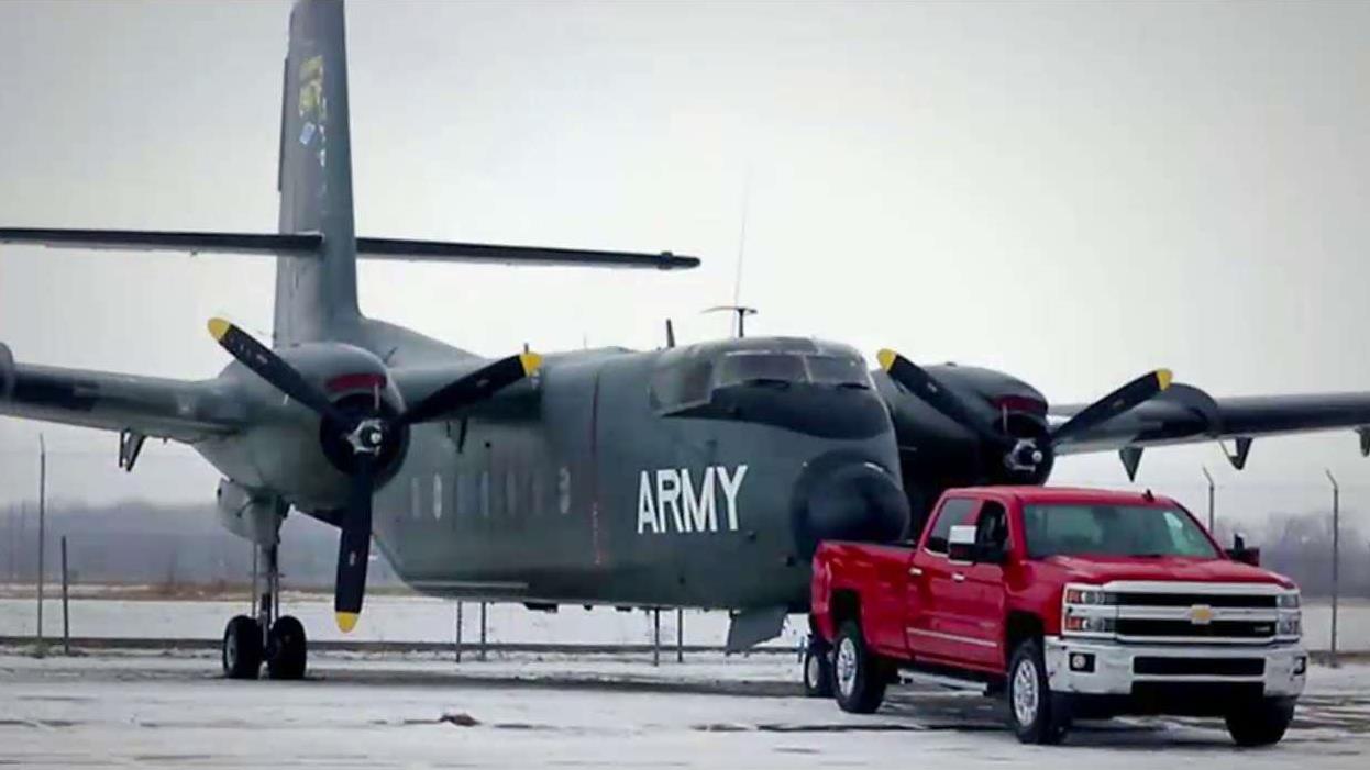 Chevy pickup truck tows historic war planes into motor plant
