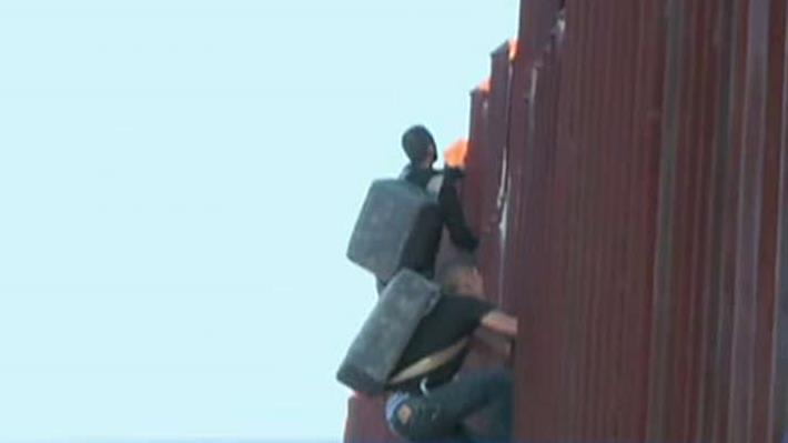 Two suspected drug smugglers caught climbing fence into US