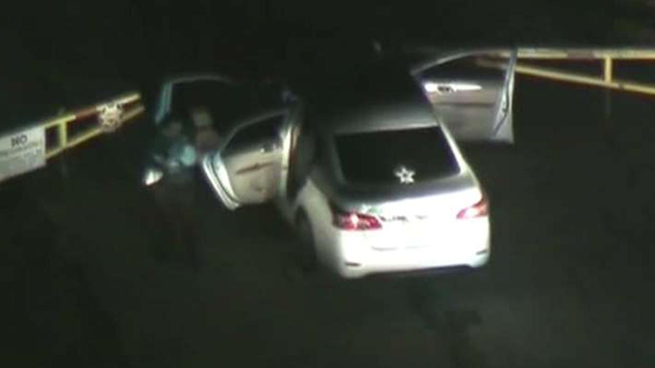Car chase suspect surrenders holding a child