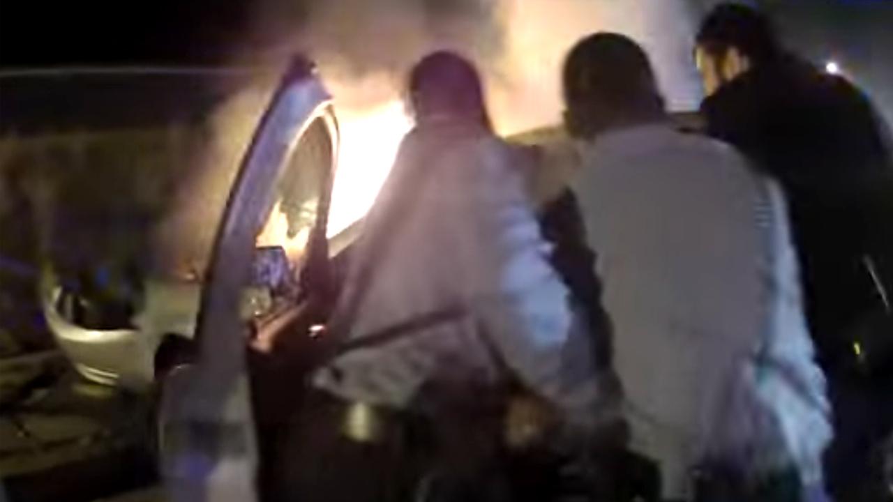 Brave cops rescue driver trapped in burning car