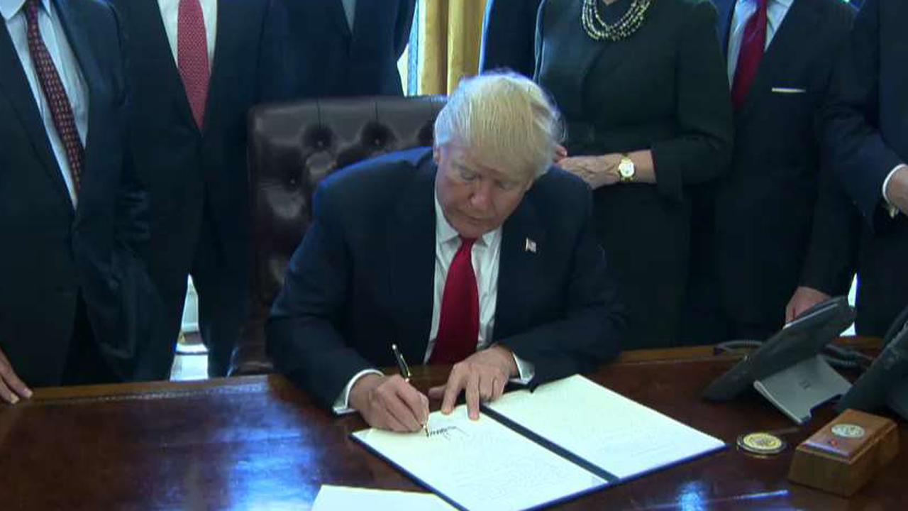 Trump signs order calling for rollback of regulations 