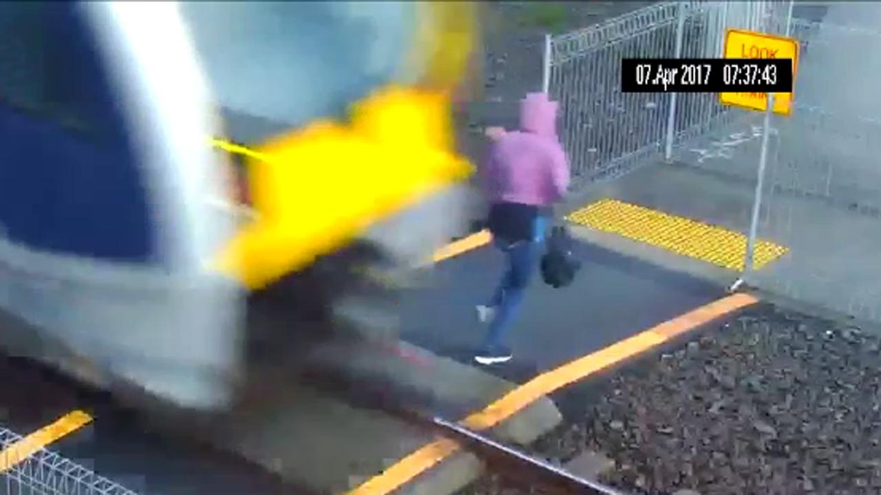 Clueless woman extremely lucky to avoid getting hit by train
