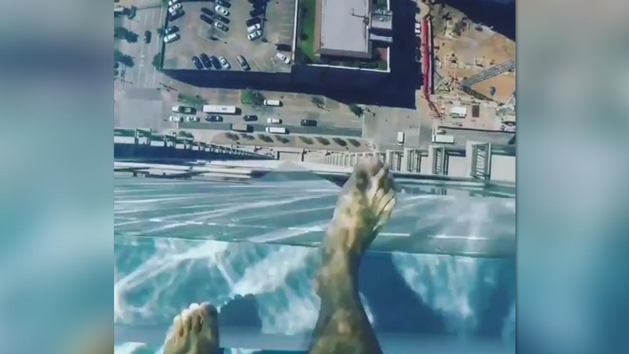 Swimming over the edge in glass bottom pool 40+ floors high