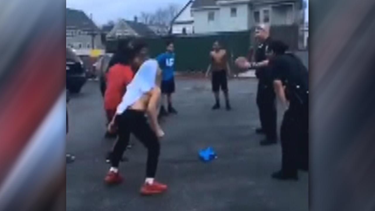 Cops play pickup game of basketball with group of kids