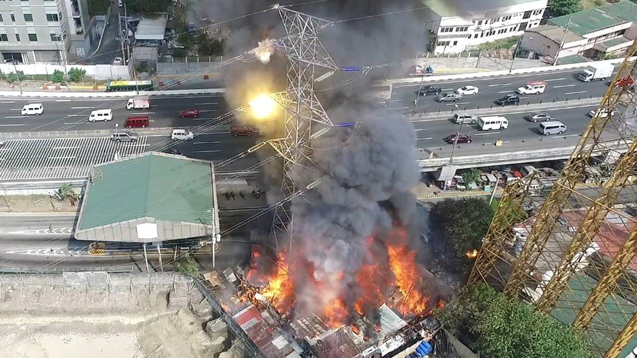 Blaze tips transmission tower toward highway