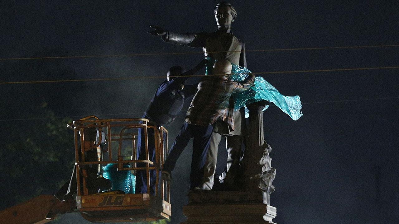 Workers don bullet proof vests to remove Confederate statue