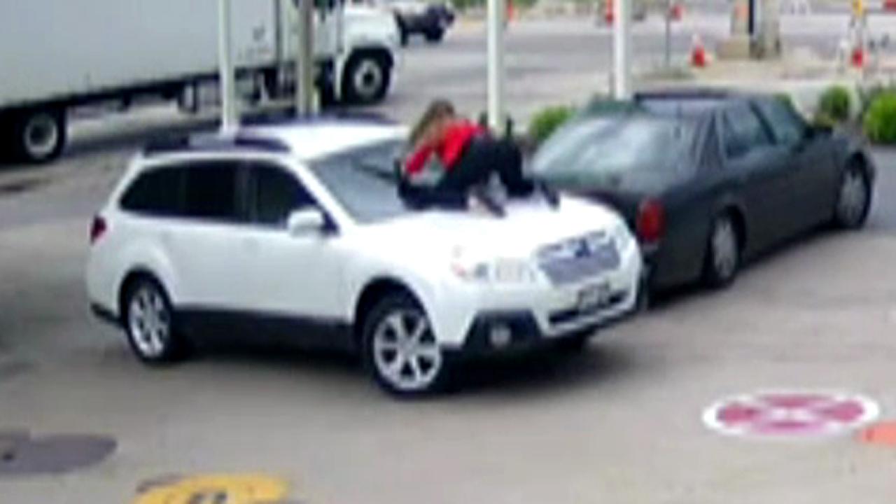 Woman jumps on SUV, hangs on for dear life to stop car thief