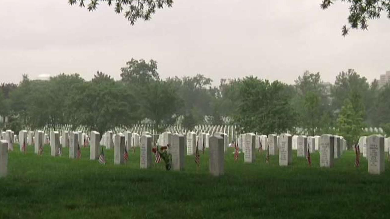 Volunteers place roses at Arlington headstones