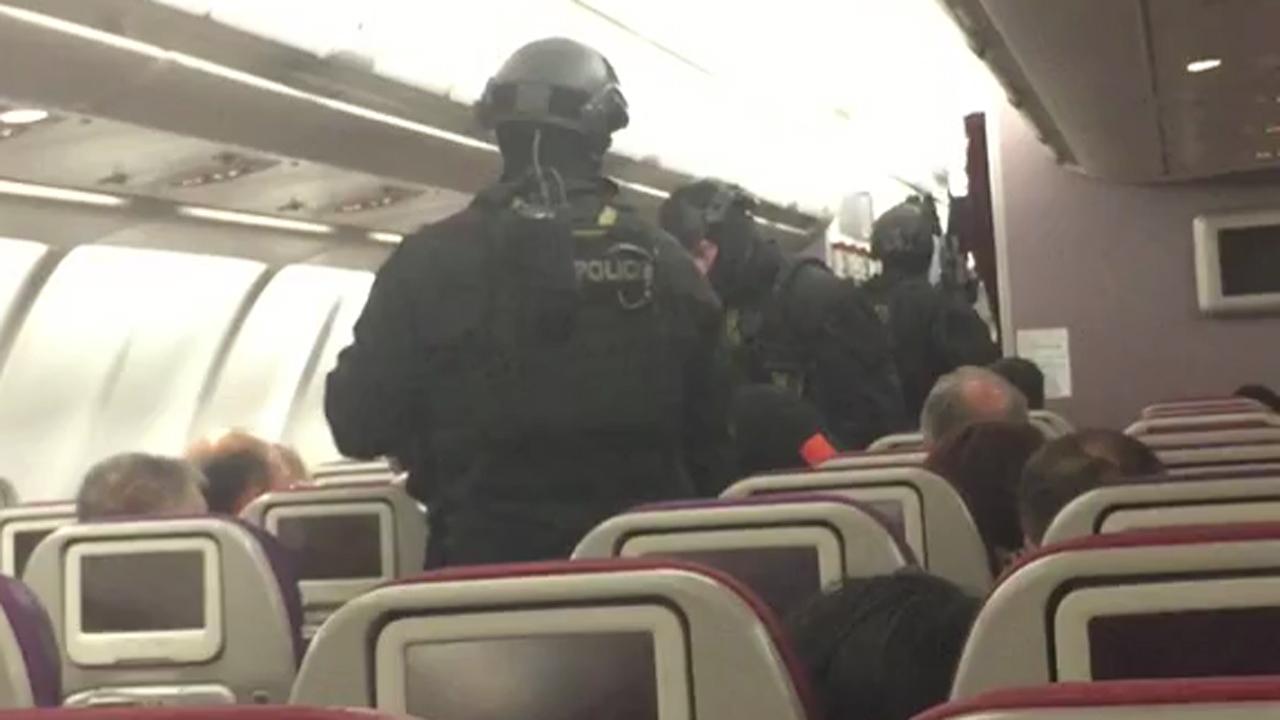 Armed police storm plane, carry man away after bomb threat