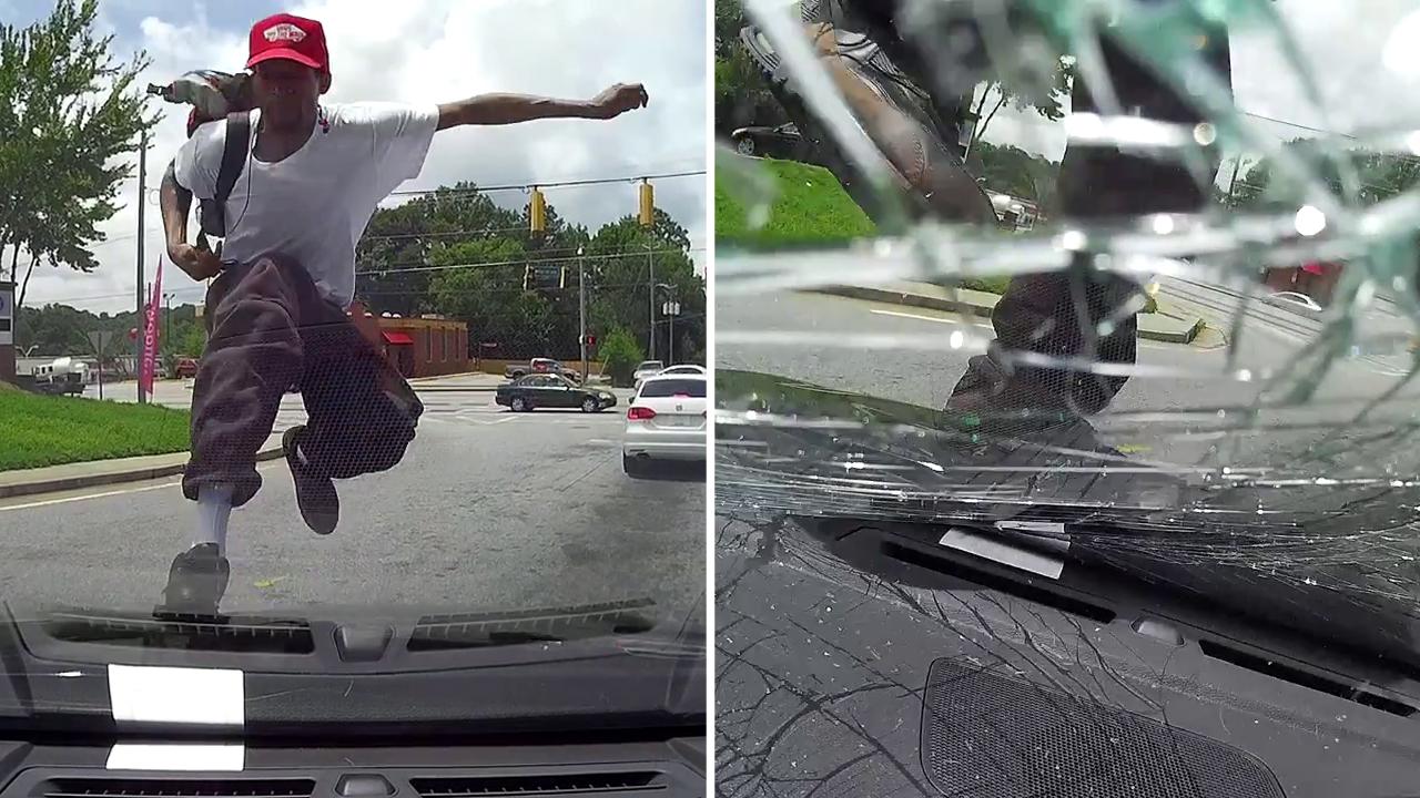 Man jumps onto moving car, kicks in windshield