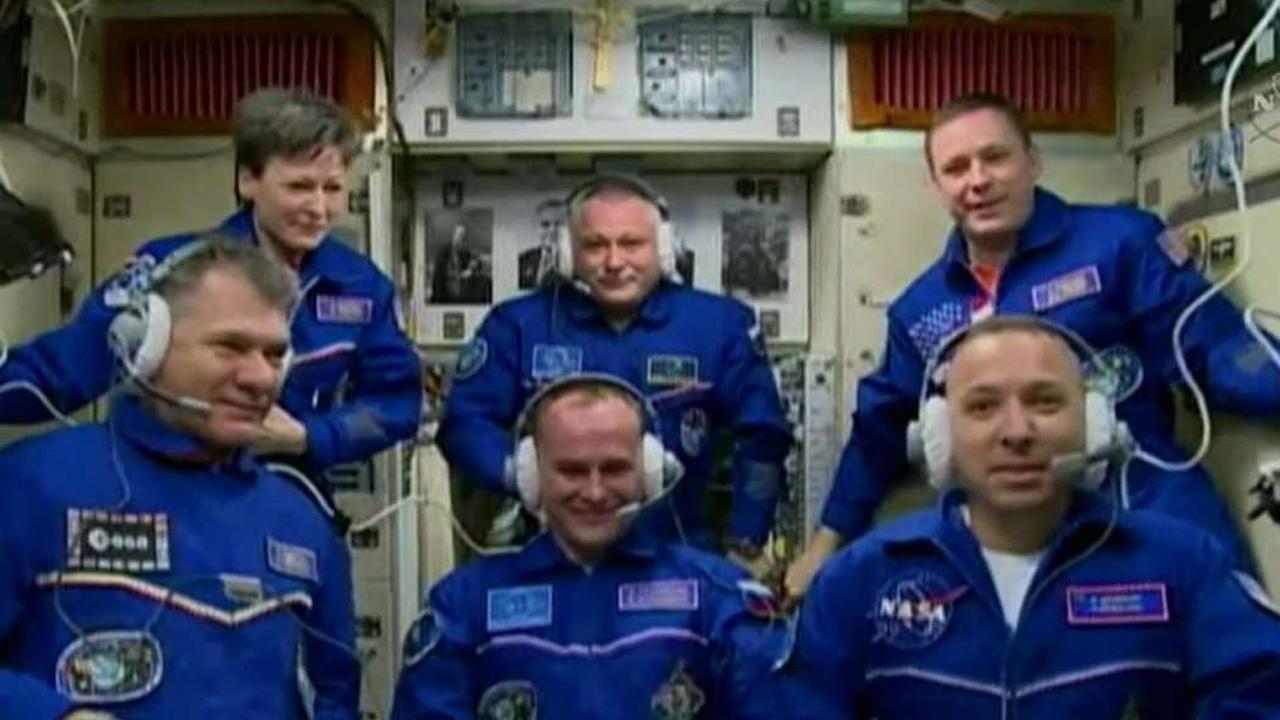 Three-man space crew docks with International Space Station