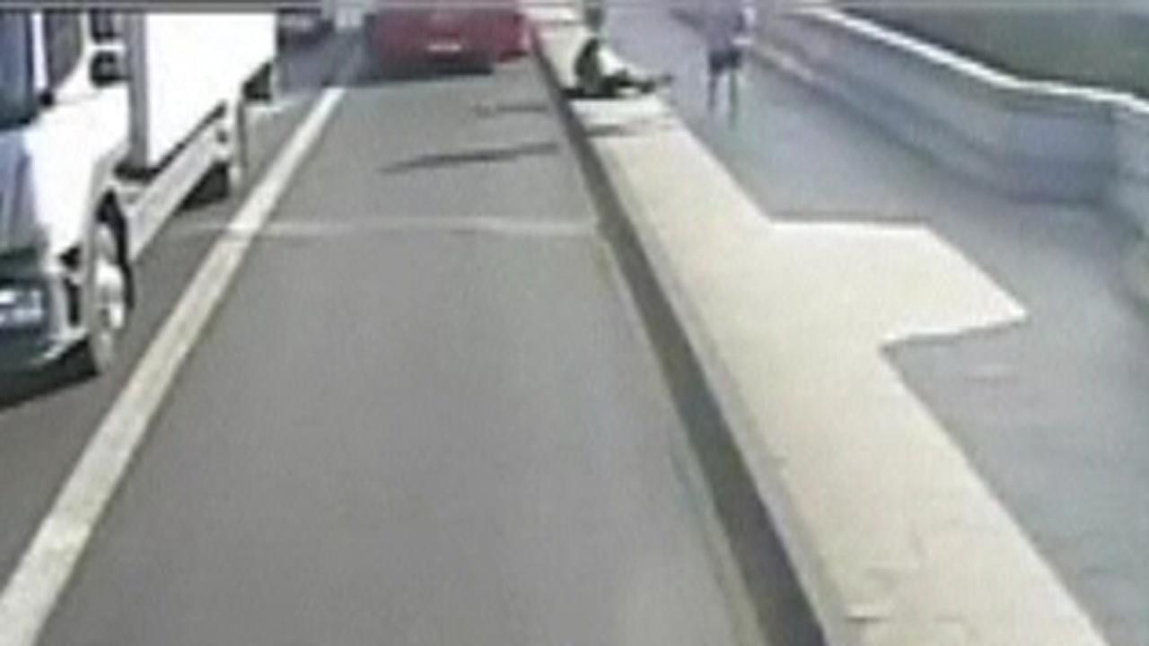 Jogger pushes woman into the road, narrowly missing a bus