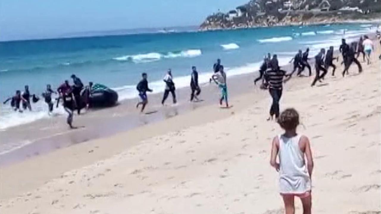 Sunbathers shocked as migrants storm Spanish beach