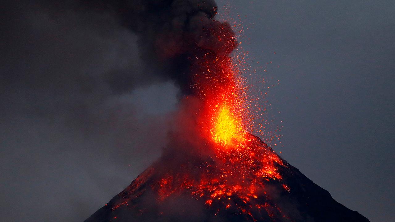 Erupting volcano lights up night sky in Philippines