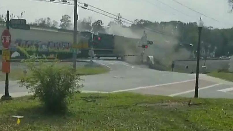 Freight train plows through tractor trailer stuck on tracks