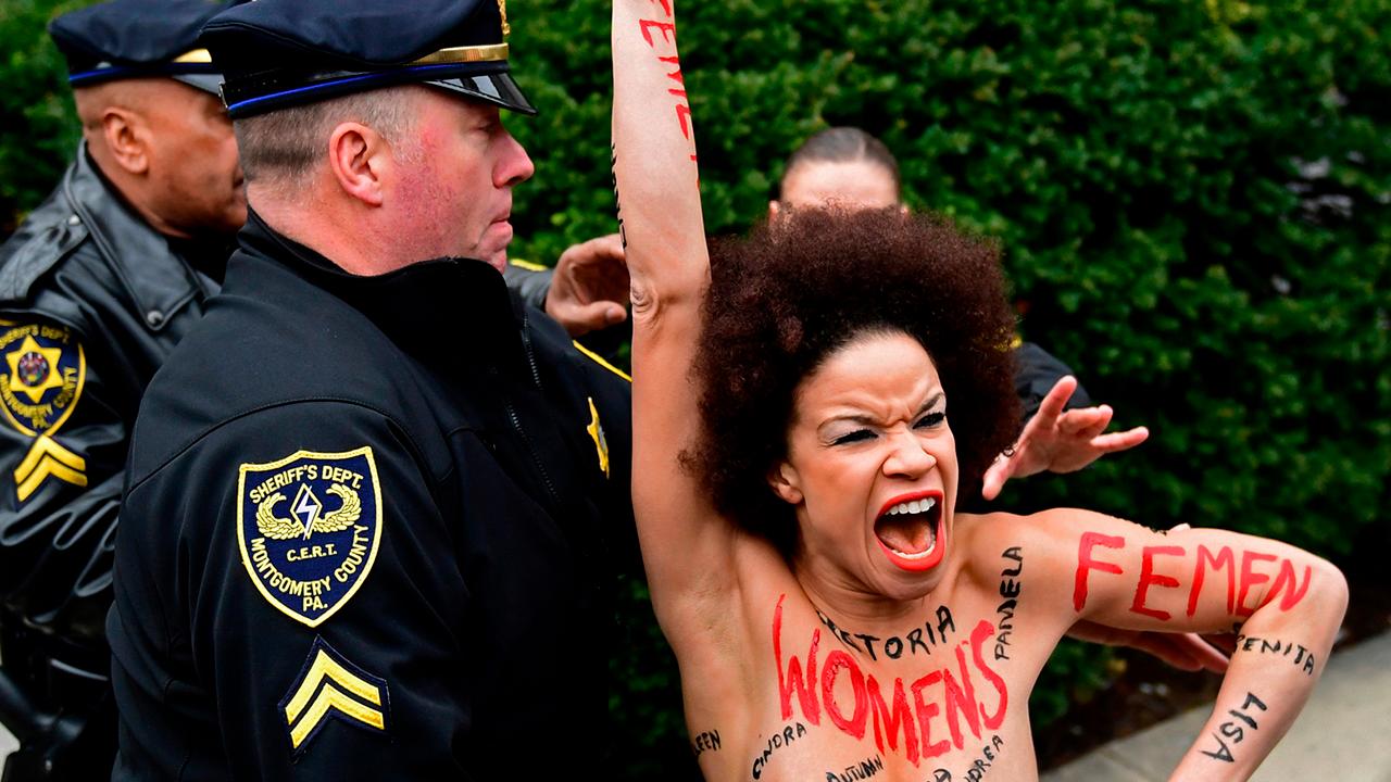 Topless protester charges Bill Cosby as he arrives for trial