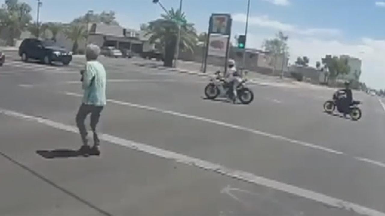Motorcyclists stop traffic to help woman cross street