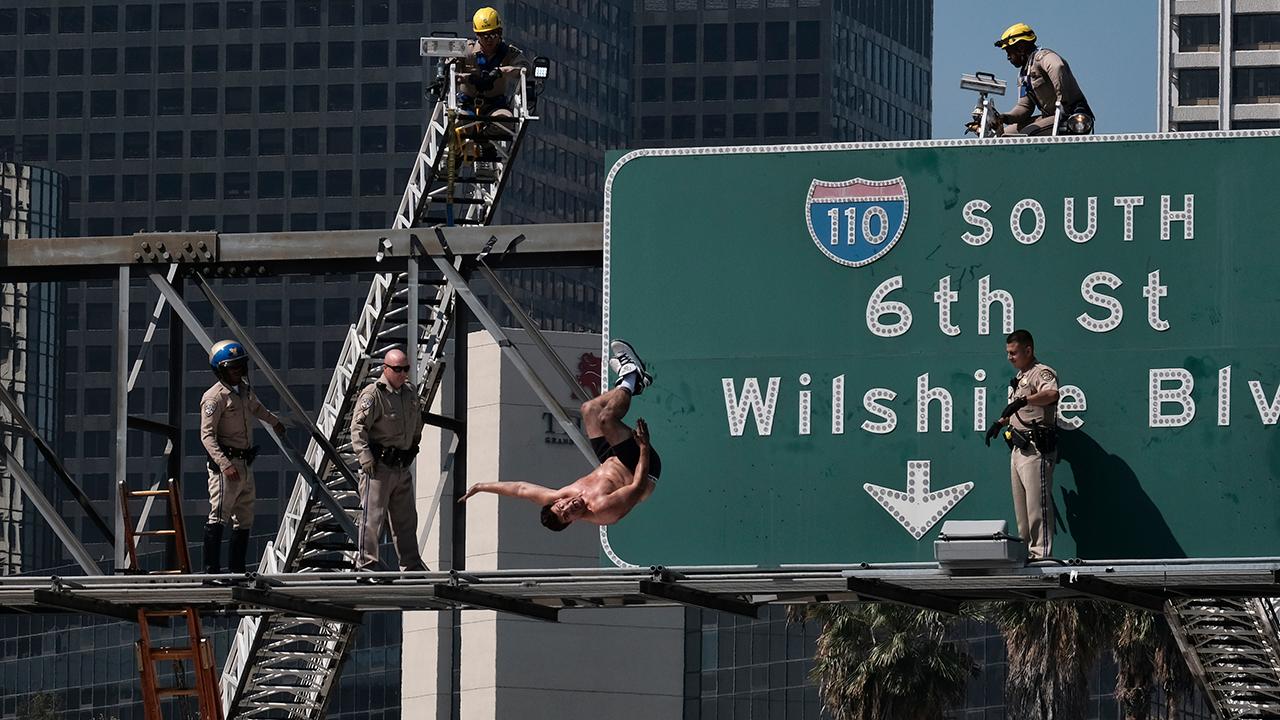 Man in underwear backflips off highway sign in Los Angeles