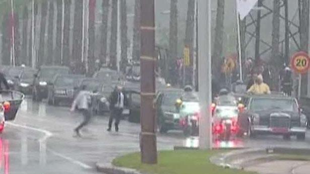 Man runs toward the motorcade of the king of Morocco and Pope Francis