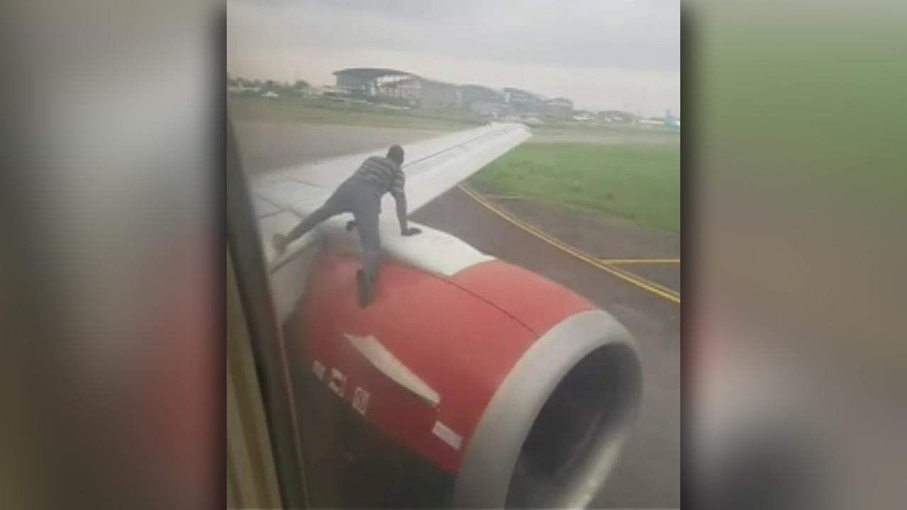 Raw video: Intruder climbs onto the engine of a plane just before takeoff from Nigeria's busiest airport