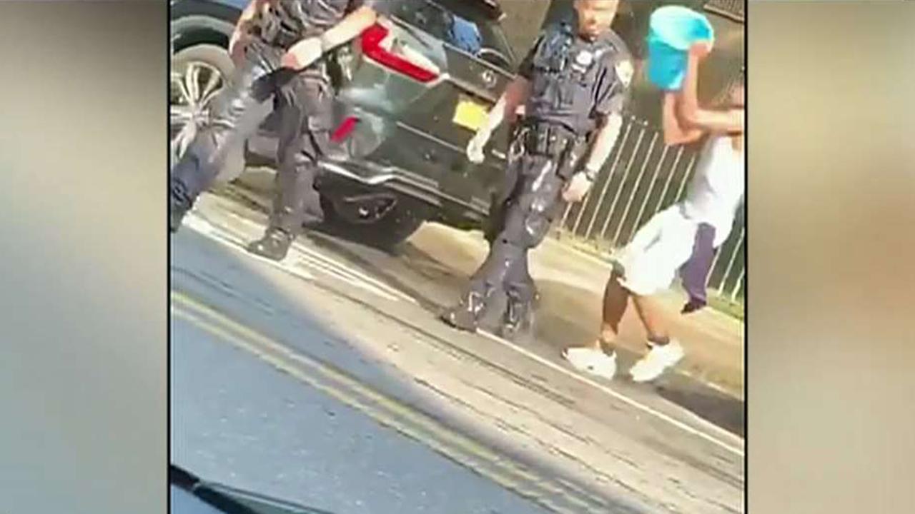 NYPD officers doused with water by group while making an arrest