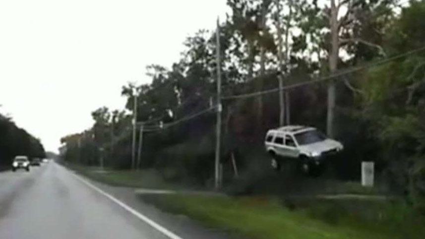 SUV flies off road, officer rushes in to help