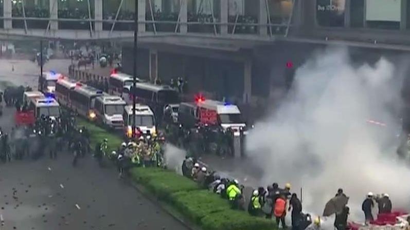 Tensions escalate in Hong Kong as police draw guns, use water cannons on protesters