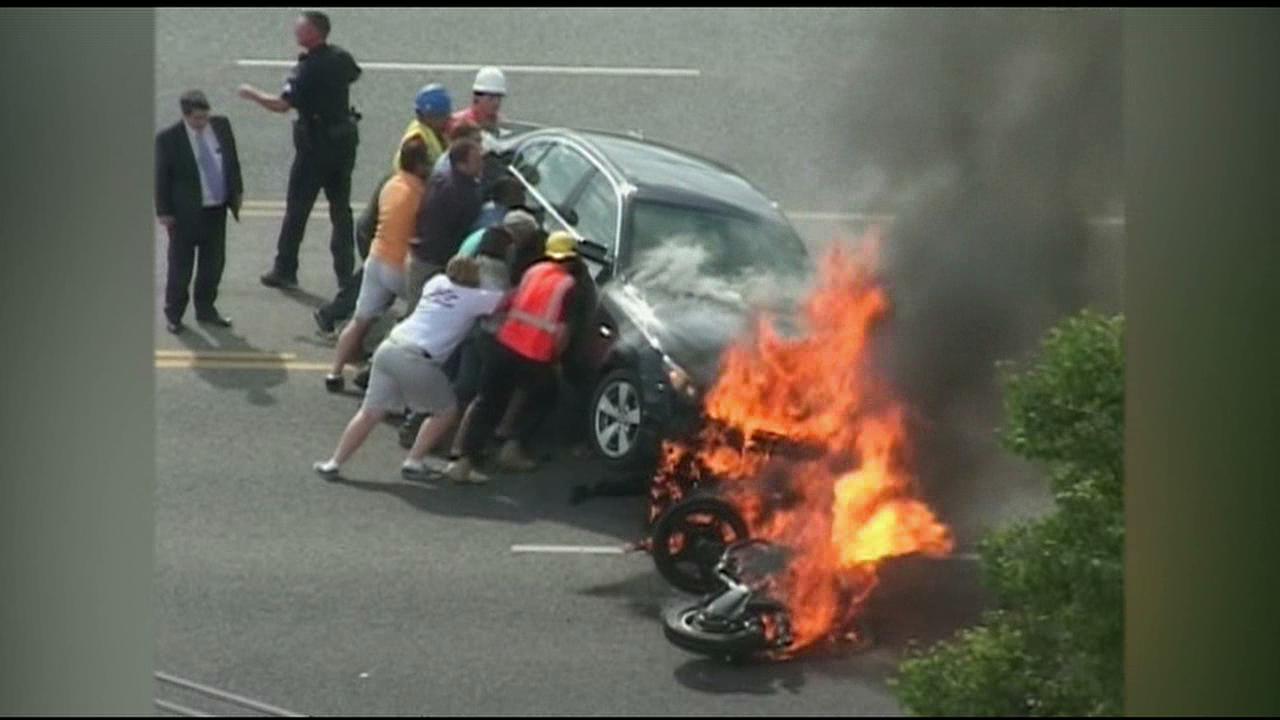 VIDEO: Motorcyclist Trapped Under Burning Car